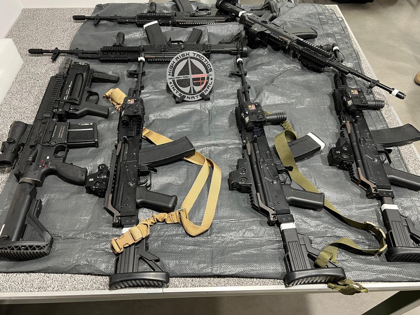 Karabiner mit Magazinen und Trageriemen auf einer Matte rund um einen High-Risk-Tactics-Aufnäher.