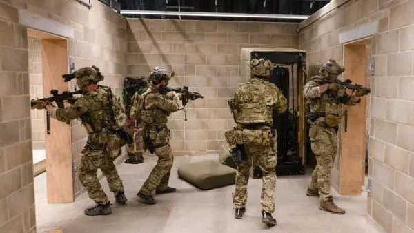 Eine Gruppe von Soldaten befindet sich in einem Raum, einige von ihnen halten Waffen.